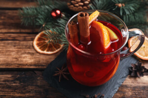 Tasty aromatic mulled wine on wooden table, closeup